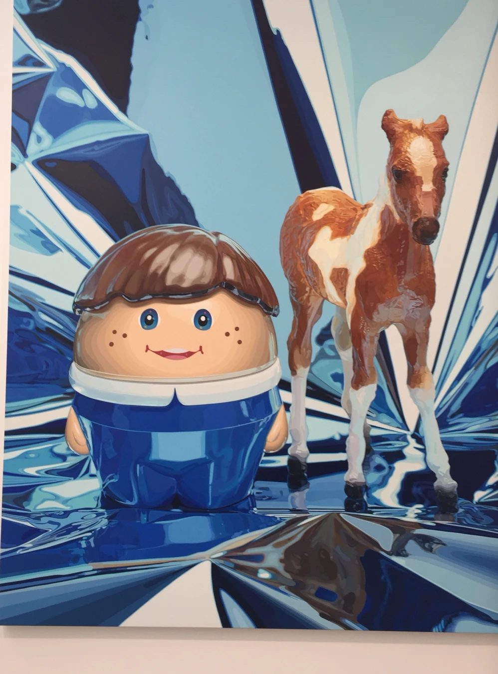 Painting of a toy egg-boy and pony against blue foil