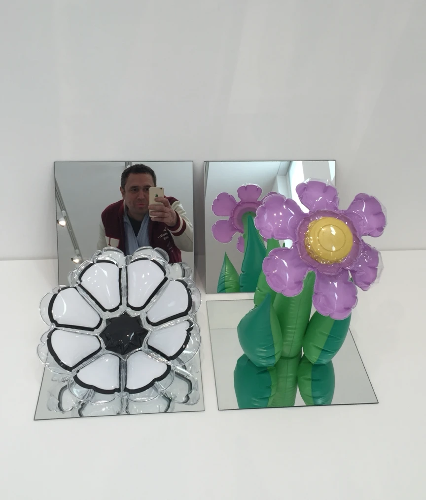 Inflatable flowers on mirrors with a visitor taking a selfie in the reflection